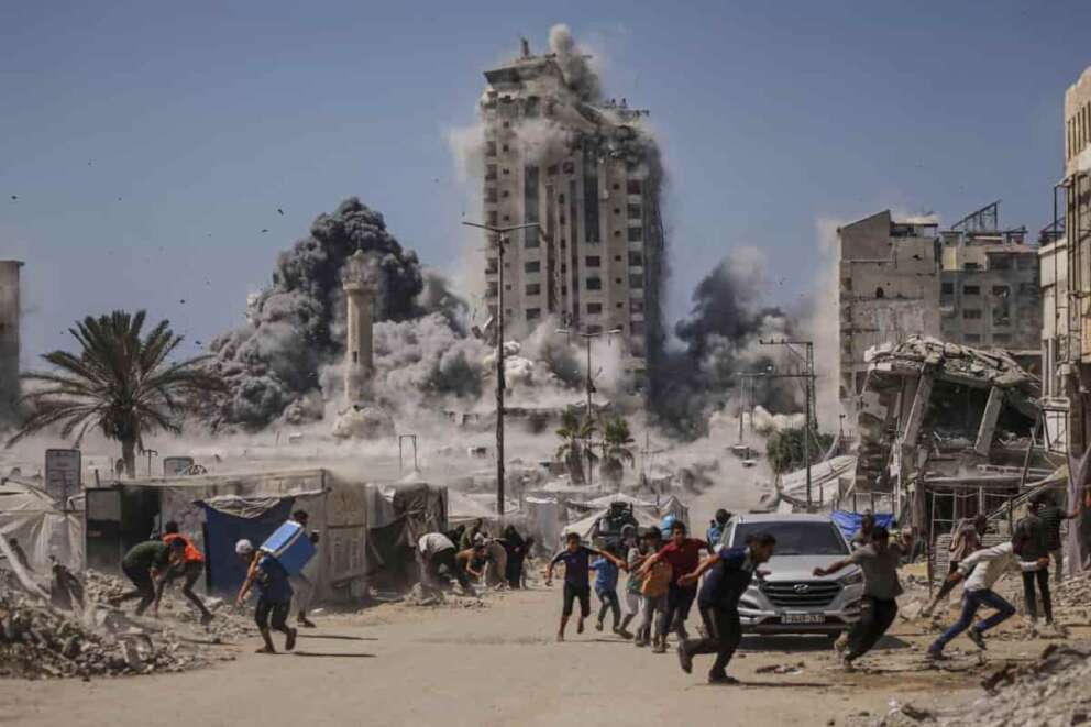 FILE – Palestinians run for cover during an Israeli airstrike on a high-rise building in Gaza City, Friday, Sept. 5, 2025, after the Israeli army issued a warning. (AP Photo/Yousef Al Zanoun, File)