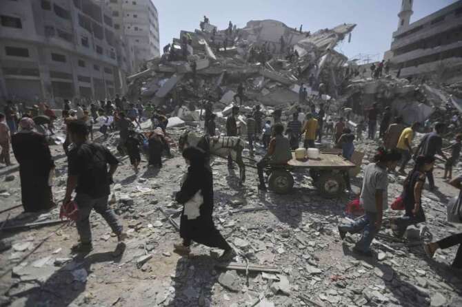 Palestinians examine the rubble of a building destroyed in an Israeli strike in Gaza City Monday, Sept. 15, 2025. (AP Photo/Yousef Al Zanoun)