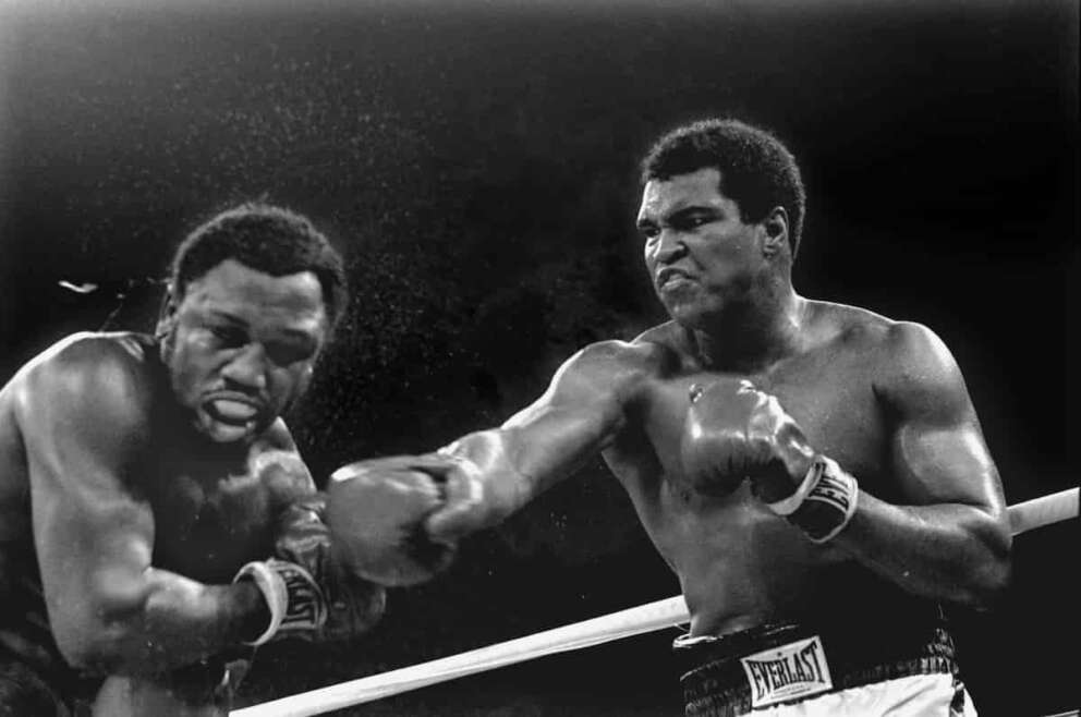 FILE – In this Oct. 1, 1975, file photo, spray flies from the head of Joe Frazier as Muhammad Ali connects with a right in the ninth round of their title fight in Manila, Philippines, Ali won the fight on a decision to retain the title. The gold standard of trilogies, both because of the fighters involved and for the way they fought. (AP Photo/Mitsunori Chigita, File)