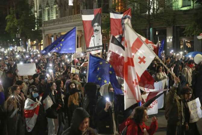 Demonstrators with EU and Georgian national flags rally to call for the release of political prisoners and demand new elections in the center of Tbilisi, Georgia, Monday, March 31, 2025. (AP Photo/Zurab Tsertsvadze)