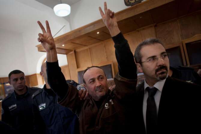 FILE – Senior Fatah leader Marwan Barghouti makes the victory sign in front of the media during his arrival to testify in a trial at a Jerusalem court, Jan. 25, 2012. (AP Photo/Bernat Armangue, File)