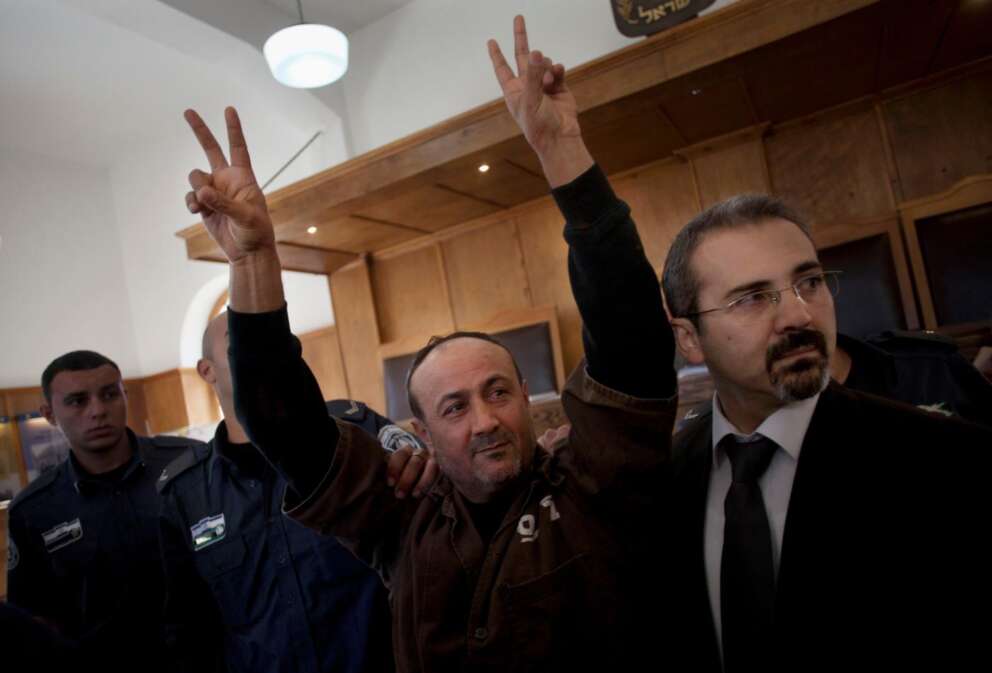 FILE – Senior Fatah leader Marwan Barghouti makes the victory sign in front of the media during his arrival to testify in a trial at a Jerusalem court, Jan. 25, 2012. (AP Photo/Bernat Armangue, File)
