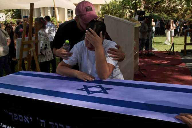Yuval, right, and Tom mourn over the coffin of their father, the slain hostage Ronen Engel, after his body was returned from Gaza as part of a ceasefire agreement between Israel and Hamas, during his funeral at Kibbutz Nir Oz, southern Israel, Tuesday, Oct. 21, 2025. (AP Photo/Leo Correa) Associated Press / LaPresse Only italy and spain