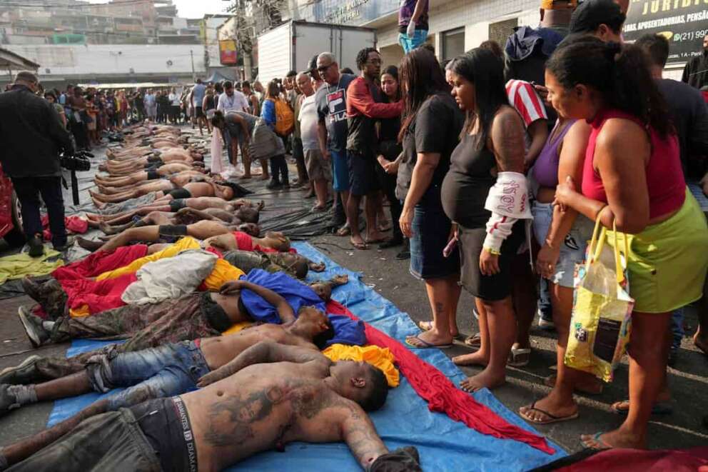 EDS NOTE: GRAPHIC CONTENT – Residents look at the bodies of people killed the day before during a police raid targeting the Comando Vermelho gang at the Complexo da Penha favela in Rio de Janeiro, Brazil, Wednesday, Oct. 29, 2025. (AP Photo/Silvia Izquierdo)