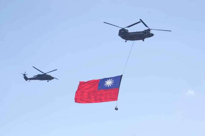 A helicopter flies over the President Office with a national flag during National Day celebrations in front of the Presidential Building in Taipei, Taiwan, Friday, Oct. 10, 2025. (AP Photo/Chiang Ying-ying)