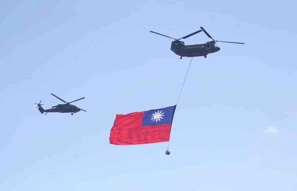 A helicopter flies over the President Office with a national flag during National Day celebrations in front of the Presidential Building in Taipei, Taiwan, Friday, Oct. 10, 2025. (AP Photo/Chiang Ying-ying)