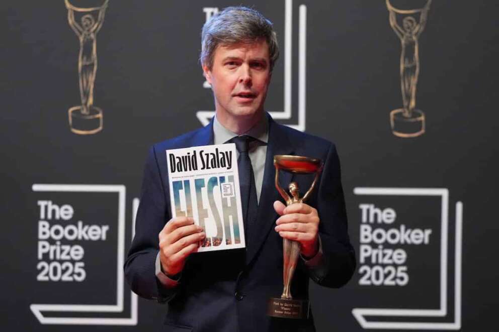 Hungarian-British author David Szalay poses for photographers with the trophy after winning the Booker Prize 2025 for his book ‘Flesh’ during a ceremony at Old Billingsgate in London, Monday, Nov. 10, 2025. (AP Photo/Kirsty Wigglesworth)
