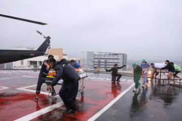In this photo provided by the Royal Thai Army, people help patients evacuate via helicopter from a flooding area to Hat Yai Hospital in Songkhla province, southern Thailand, Wednesday, Nov. 26, 2025. (AP Photo/Royal Thai Army via AP)