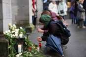 People lay flowers and candles on the national day of mourning at the Muensterplatz, Zurich, Switzerland, Friday Jan. 9, 2026, following the deadly fire at the “Le Constellation” bar in Crans-Montana. (Claudio Thoma/Keystone via AP)