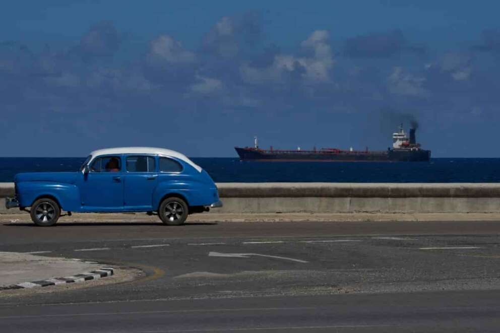 A classic American car drives along the seafront promenade as a tanker sails into the bay of Havana, Cuba, Saturday, Feb. 14, 2026. (AP Photo/Ramon Espinosa)