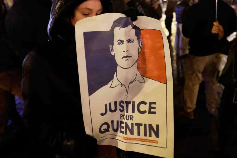 A woman holds a placard reading “Justice for Quentin” as she gathers to pay tribute to far-right student, Quentin Deranque, 23, who died in Lyon from a street beating during clashes between far-left and far-right militants, in Lille, northern France, Wednesday, Feb. 18, 2026. (AP Photo/Jean-Francois Badias)