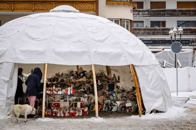 Mourners gather around flowers and candles to commemorate the victims of the “Le Constellation” bar and lounge’s fire, in Crans-Montana, Switzerland, Thursday, Jan. 8, 2026. (Jean-Christophe Bott/Keystone via AP) Associate Press/ LaPresse Only Italy and Spain
