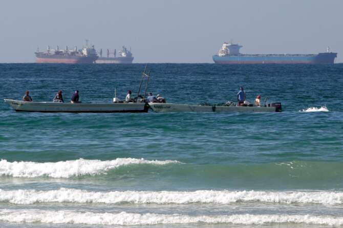 FILE – Fishermen work in front of oil tankers south of the Strait of Hormuz Jan. 19, 2012, offshore the town of Ras Al Khaimah in United Arab Emirates. (AP Photo/Kamran Jebreili, File)