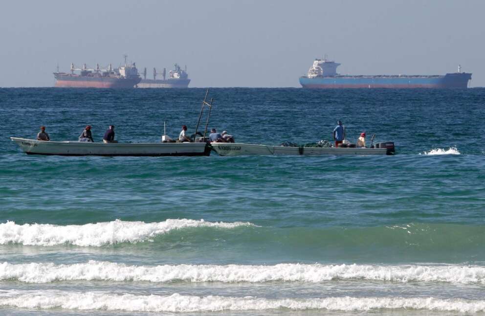 FILE – Fishermen work in front of oil tankers south of the Strait of Hormuz Jan. 19, 2012, offshore the town of Ras Al Khaimah in United Arab Emirates. (AP Photo/Kamran Jebreili, File)
