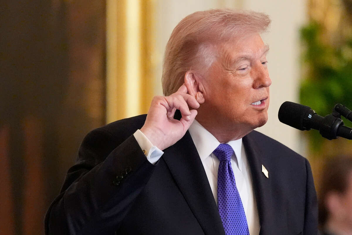 President Donald Trump touches his ear as he talks about the noise from the new ballroom construction before a Medal of Honor ceremony in the East Room of the White House, Monday, March 2, 2026, in Washington.(AP Photo/Mark Schiefelbein)