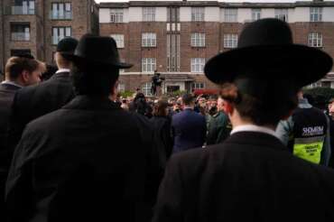 People gather to listen to Britain’s Secretary of State for Health and Social Care Wes Streeting, as he speaks to the media in London, Monday, March 23, 2026 after an apparent arson attack on four vehicles belonging to a Jewish ambulance service, Hatzola Northwest, in London.(AP Photo/Alberto Pezzali)