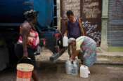 People fill jugs with water in Havana, Cuba, Friday, June 12, 2026. (AP Photo/Ramon Espinosa)