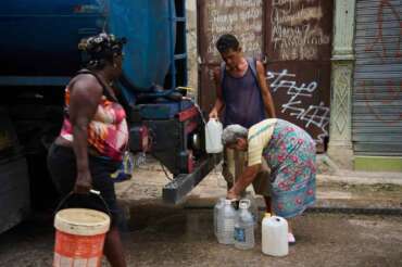 People fill jugs with water in Havana, Cuba, Friday, June 12, 2026. (AP Photo/Ramon Espinosa)