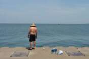 A man fishes Lake Michigan, off the North Pier in St. Joseph, Mich., Tuesday, June 30, 2026. (Don Campbell/The Herald-Palladium via AP)