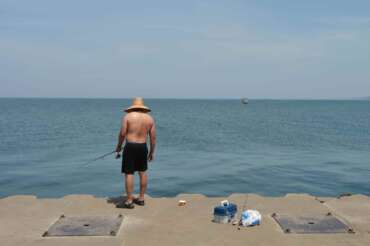A man fishes Lake Michigan, off the North Pier in St. Joseph, Mich., Tuesday, June 30, 2026. (Don Campbell/The Herald-Palladium via AP)