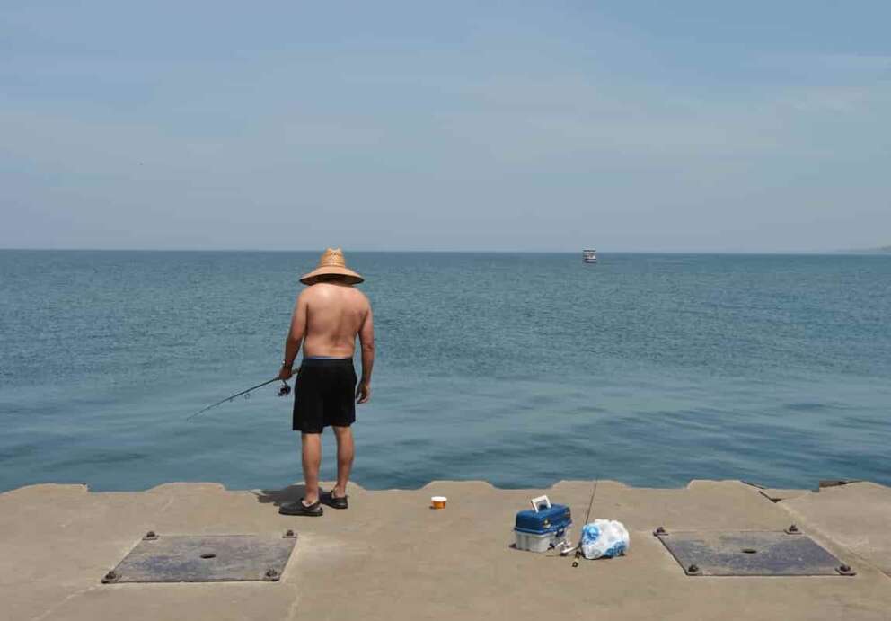 A man fishes Lake Michigan, off the North Pier in St. Joseph, Mich., Tuesday, June 30, 2026. (Don Campbell/The Herald-Palladium via AP)