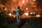 A woman takes photo of destructions following Russian missile attacks in Kyiv, Ukraine, Monday, July 6, 2026. (AP Photo/Danylo Antoniuk) Associate Press/ LaPresse Only Italy and Spain